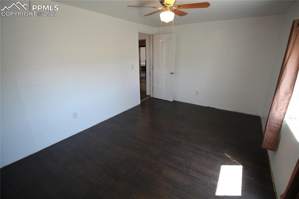 1526 Noe Road Larkspur, CO 80118 - Photo 15 of 29 an empty room with wooden floor fan and window