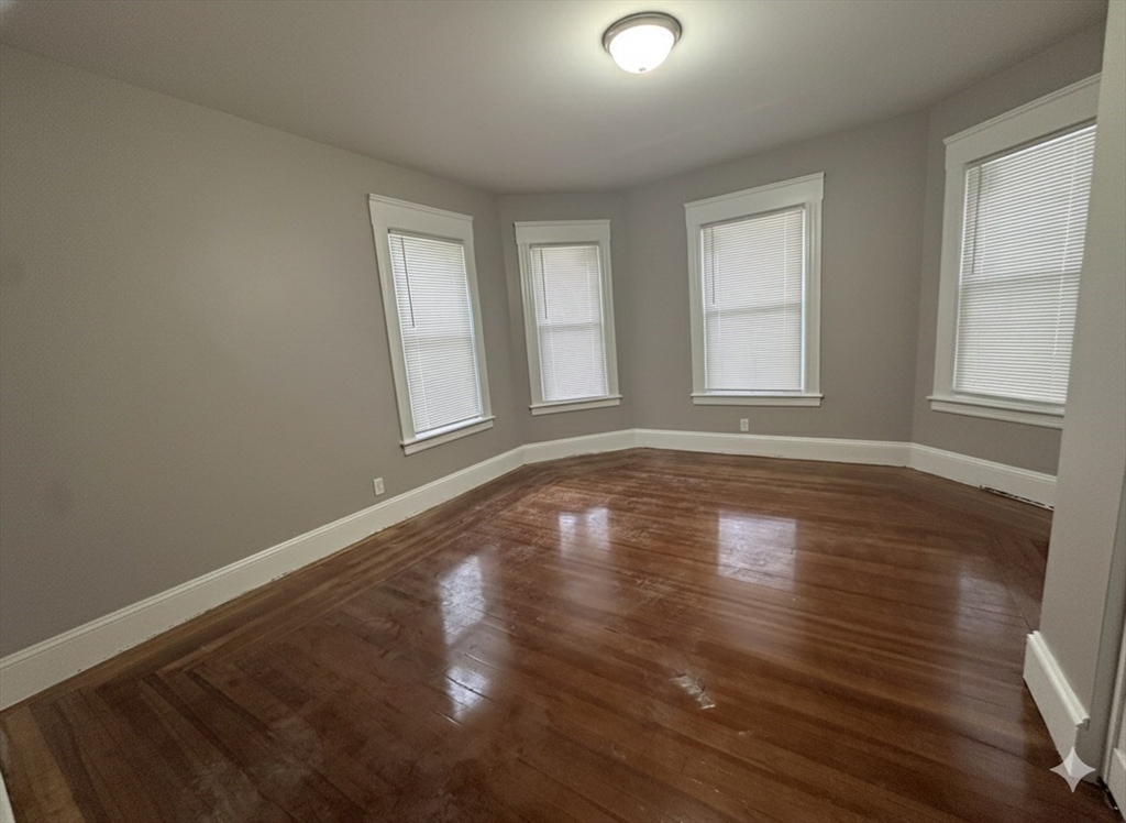 37 Cortland Street, Unit 1 Springfield, MA 01109 - Photo 9 of 14 an empty room with wooden floor and windows