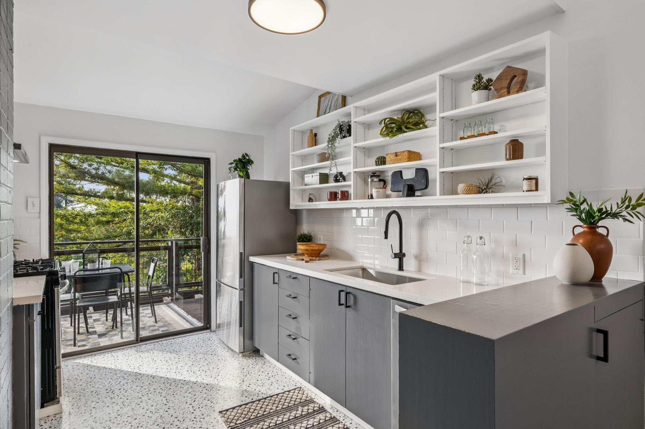 1024 Miller Avenue Berkeley, CA 94708 - Photo 19 of 60 Kitchen with freestanding refrigerator, dark aggregate flooring, gray cabinets, vaulted ceiling, and range with gas stovetop
