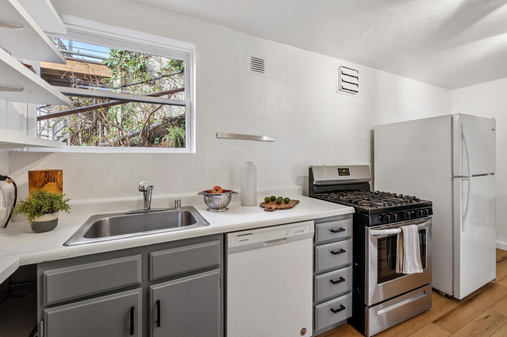 1024 Miller Avenue Berkeley, CA 94708 - Photo 39 of 60 Kitchen featuring gray cabinetry, white appliances, light countertops, and light wood finished floors
