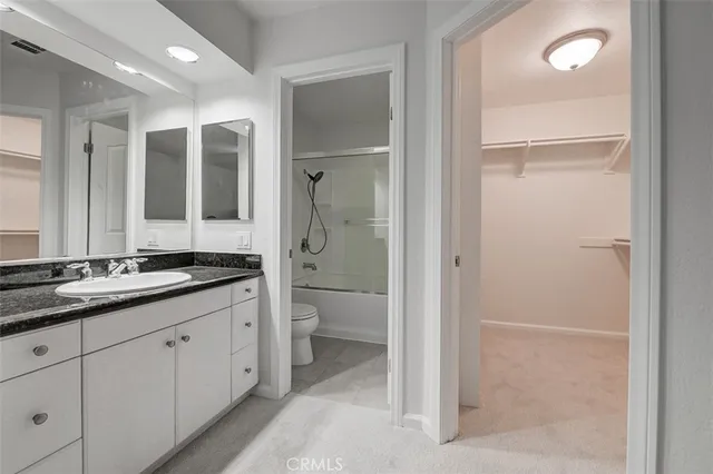 a spacious bathroom with a granite countertop sink mirror and toilet