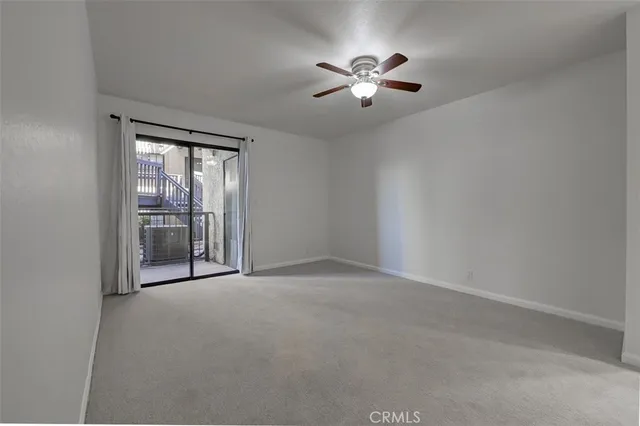 a view of an empty room with a chandelier fan