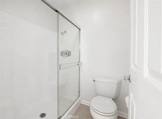a white toilet sitting next to a shower