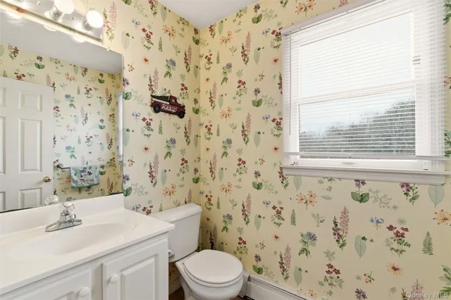 a bathroom with a sink a toilet and a window