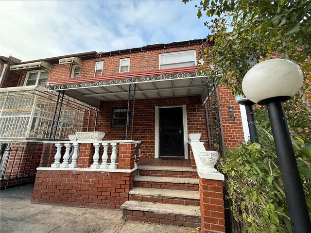 a view of a house with a large window and plants
