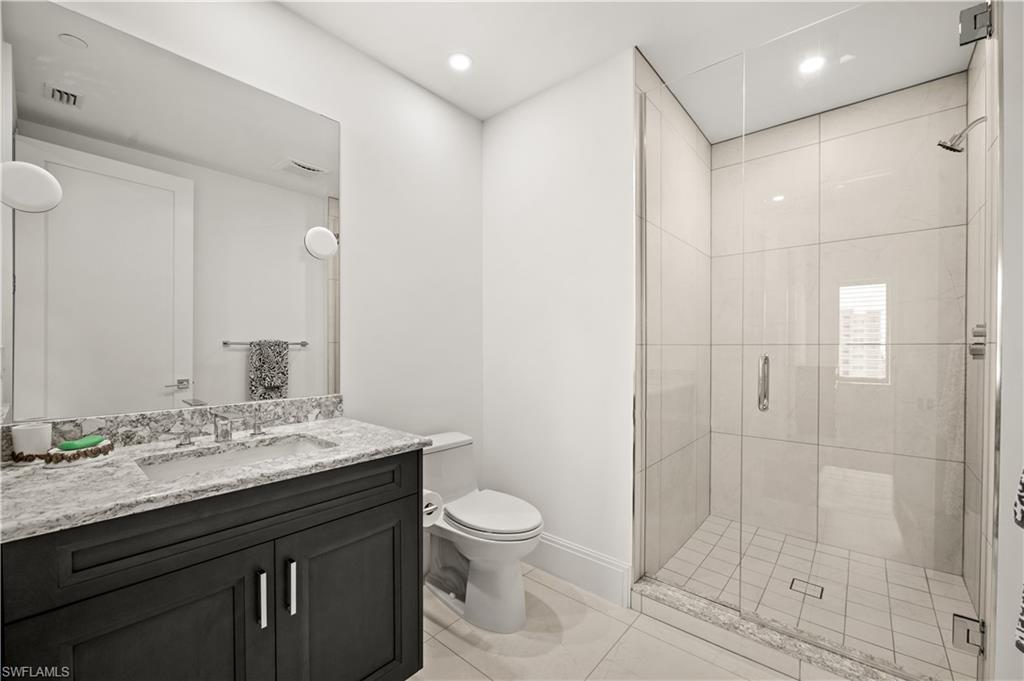1130 3rd Avenue South, Unit 309 Naples, FL 34102 - Photo 13 of 29 a bathroom with a granite countertop sink a toilet and shower