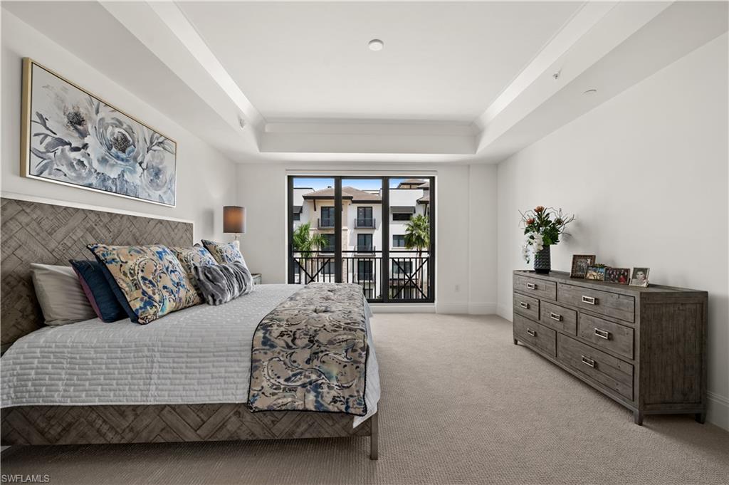 1130 3rd Avenue South, Unit 309 Naples, FL 34102 - Photo 17 of 29 a living room with a large bed and a dresser