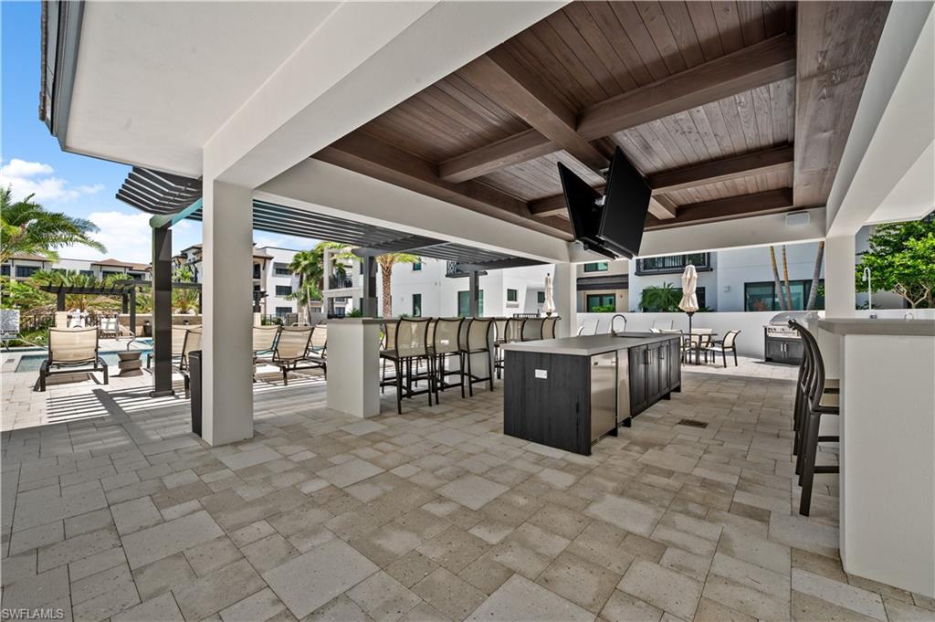 1130 3rd Avenue South, Unit 309 Naples, FL 34102 - Photo 23 of 29 a view of a patio with table and chairs