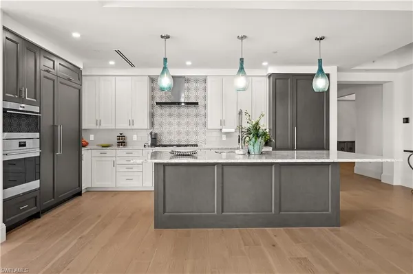 a large kitchen with granite countertop a large counter top space appliances and cabinets