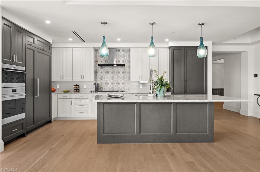 1130 3rd Avenue South, Unit 309 Naples, FL 34102 - Photo 5 of 29 a large kitchen with granite countertop a large counter top space appliances and cabinets