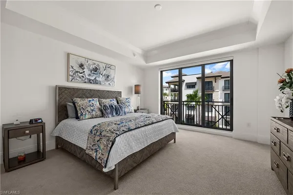 a spacious bedroom with a bed painting and a large window