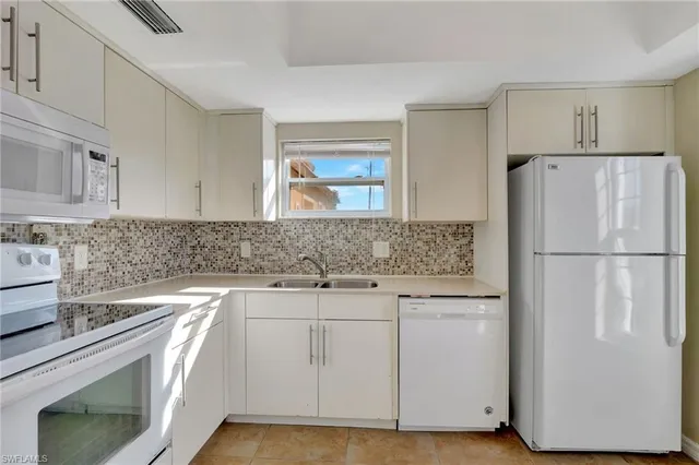 a kitchen with a refrigerator sink and cabinets