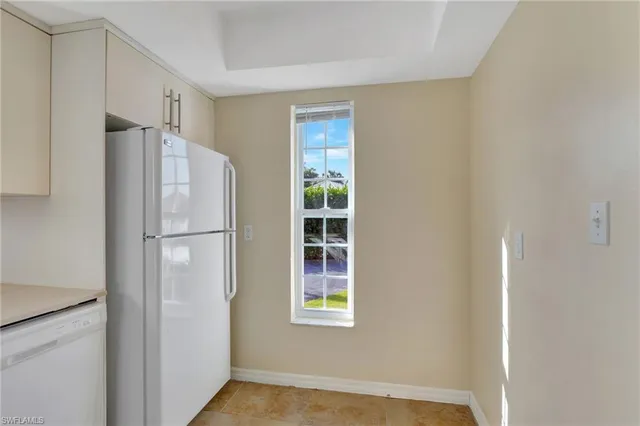 a view of a kitchen with a refrigerator and window