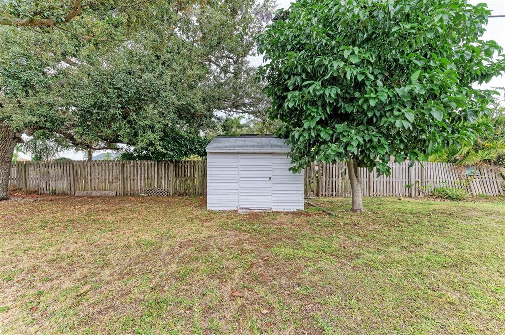 4424 87th St Court West Bradenton, FL 34210 - Photo 39 of 40 a view of a backyard with large trees and wooden fence