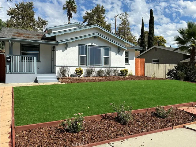 a front view of a house with a garden and yard