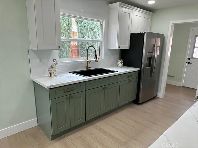 a kitchen with stainless steel appliances granite countertop a refrigerator and a sink