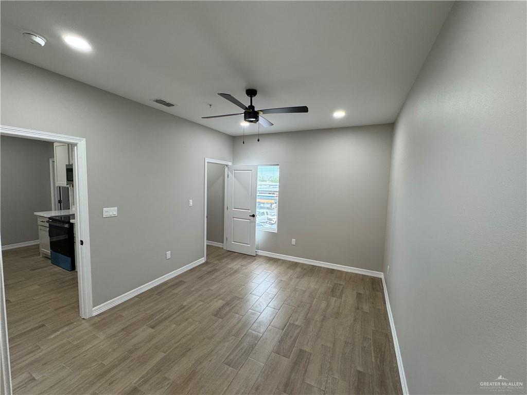 800 Ragland Road, Unit 10 Mission, TX 78572 - Photo 6 of 13 an empty room with wooden floor and a ceiling fan
