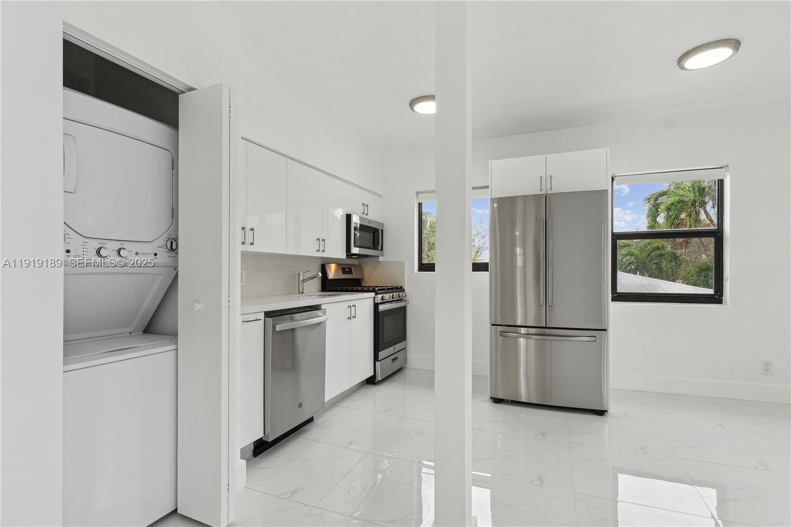 8010 Crespi Boulevard, Unit 4 Miami Beach, FL 33141 - Photo 1 of 16 a kitchen with cabinets and refrigerator