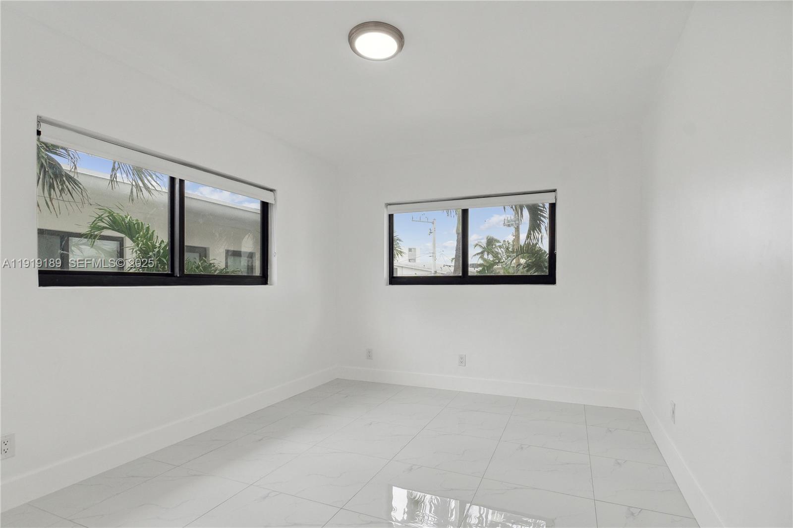 8010 Crespi Boulevard, Unit 4 Miami Beach, FL 33141 - Photo 11 of 16 an empty room with windows