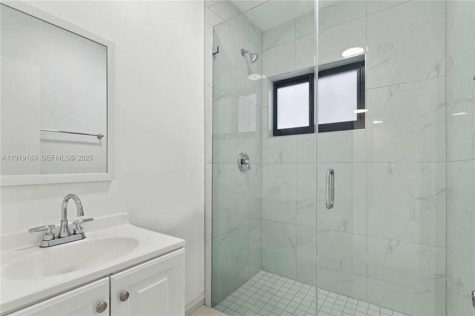 8010 Crespi Boulevard, Unit 4 Miami Beach, FL 33141 - Photo 6 of 16 a bathroom with a sink a vanity and a mirror