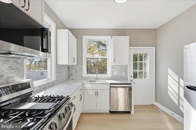 a kitchen with stainless steel appliances a stove a sink and a microwave