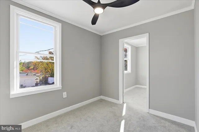 an empty room with a window and a fan