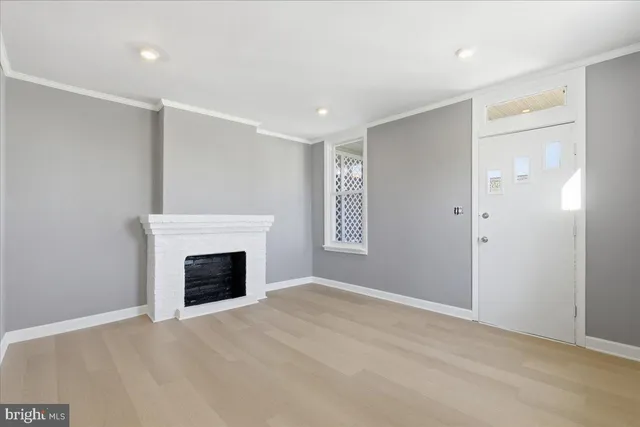 a view of an empty room with a fireplace and a window