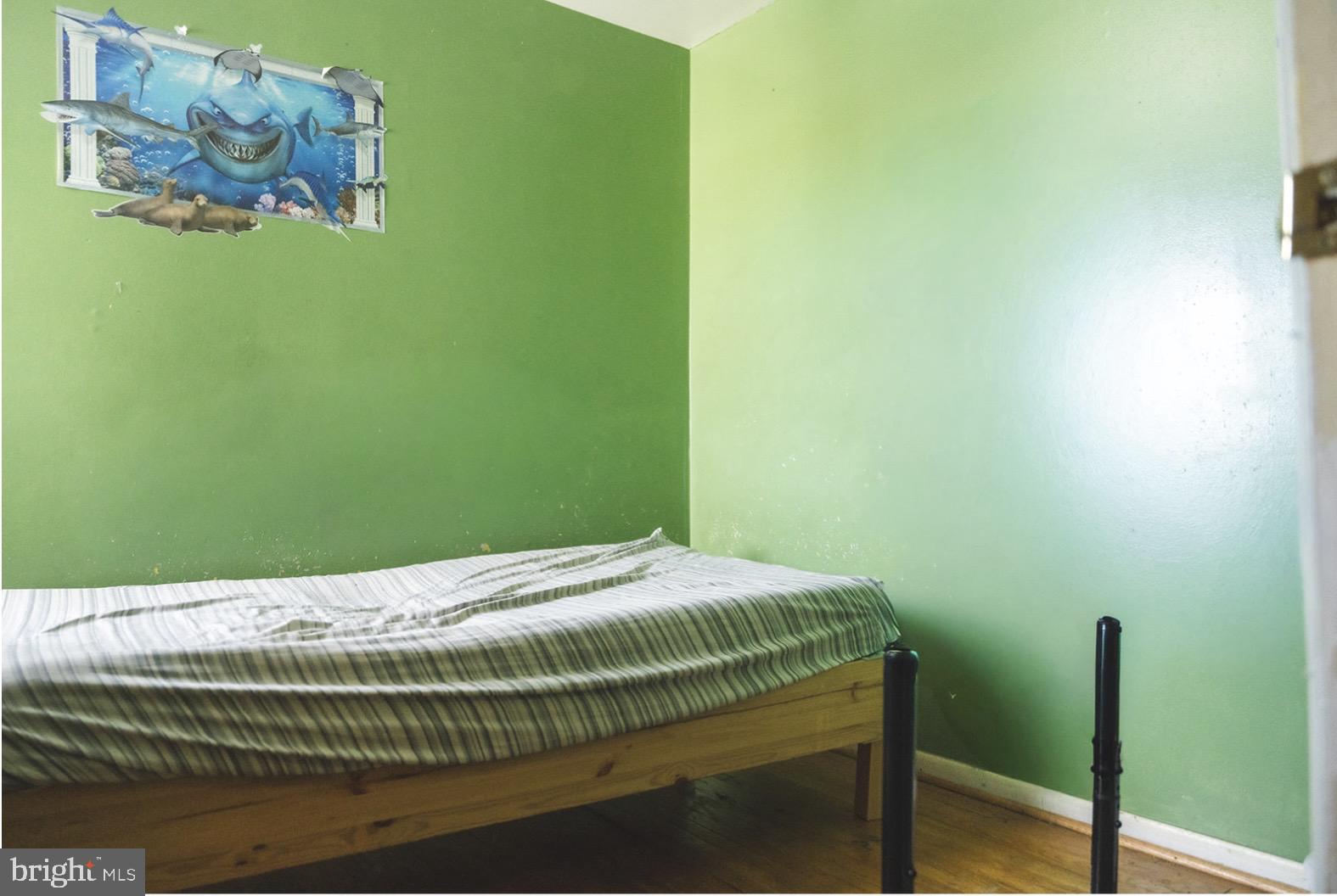 6021 Chestnut Street Philadelphia, PA 19139 - Photo 18 of 21 a bedroom with a bed and a wall painting