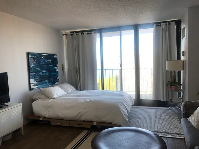 a bedroom with a bed dresser and a window