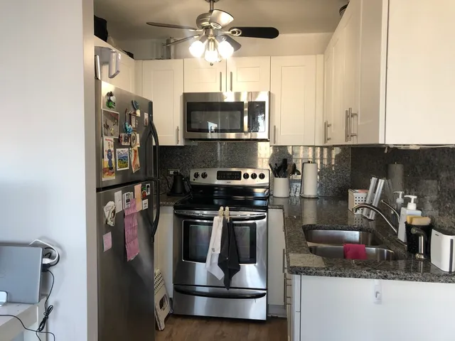a kitchen with stainless steel appliances granite countertop a refrigerator and a stove