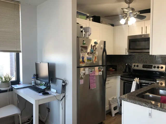 a kitchen with stainless steel appliances granite countertop a stove refrigerator and a microwave