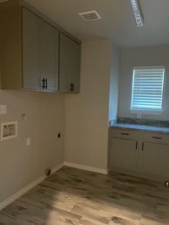 a view of a kitchen with wooden floor and cabinets