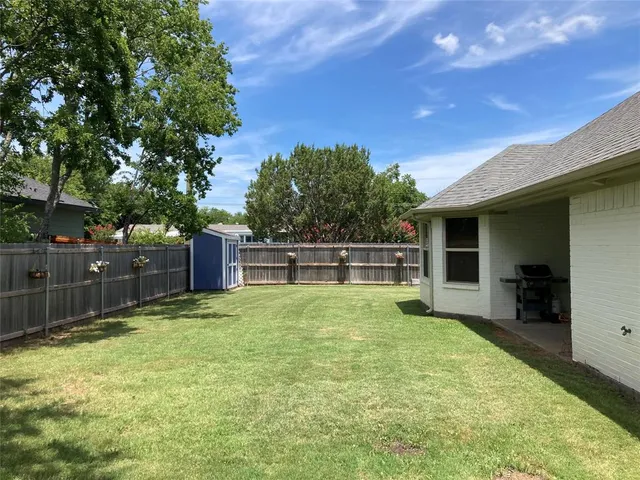 a backyard of a house with table and chairs