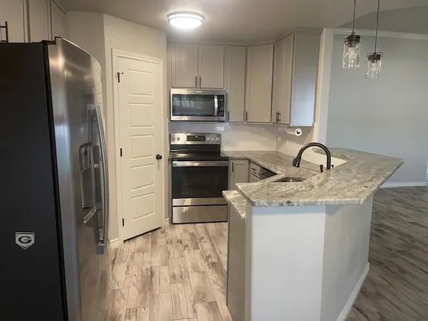 a kitchen with stainless steel appliances granite countertop a refrigerator and a sink