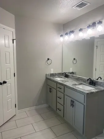 a bathroom with a granite countertop sink and a mirror