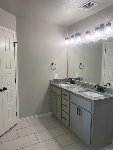 a bathroom with a granite countertop sink and a mirror