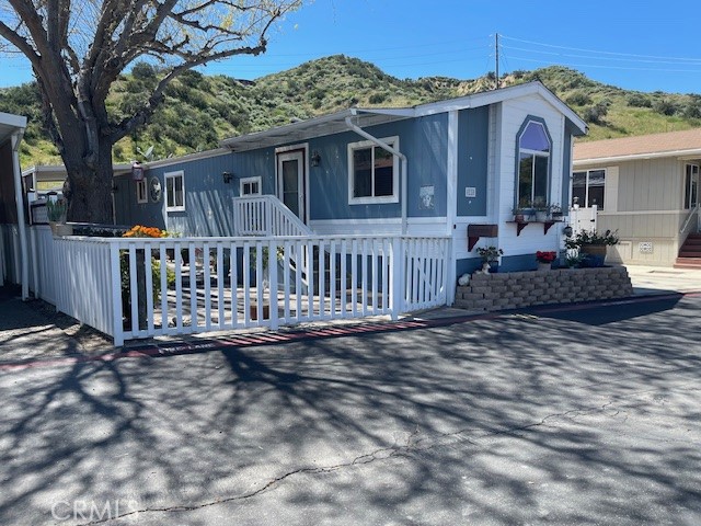 30000 Hasley Canyon Road, Unit 11 Castaic, CA 91384 - Photo 1 of 1 a view of a house with a wooden deck and furniture