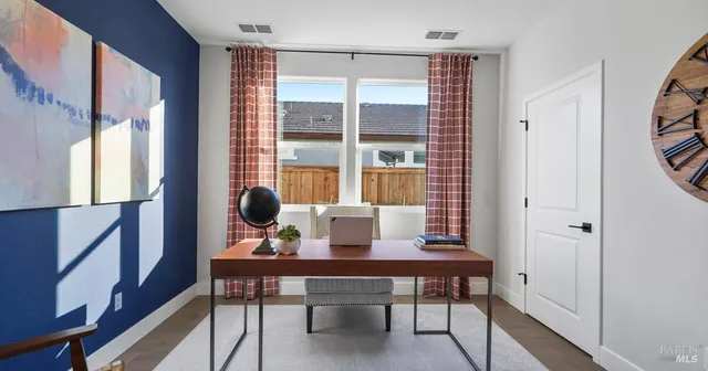 a view of a workspace with furniture and a window