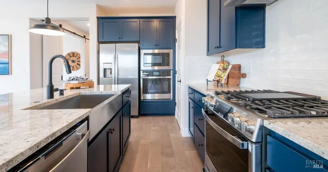 a kitchen with granite countertop stainless steel appliances and wooden cabinets