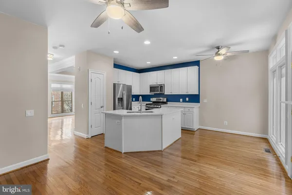 a kitchen with stainless steel appliances kitchen island a refrigerator sink and cabinets