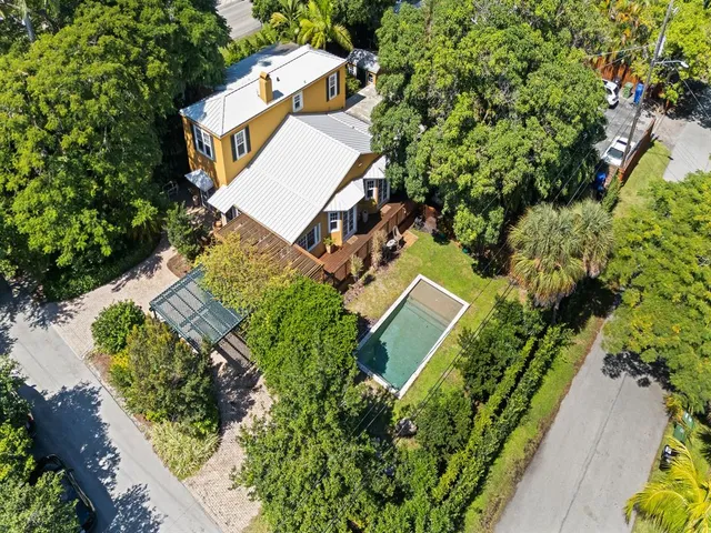an aerial view of a house with a yard and trees