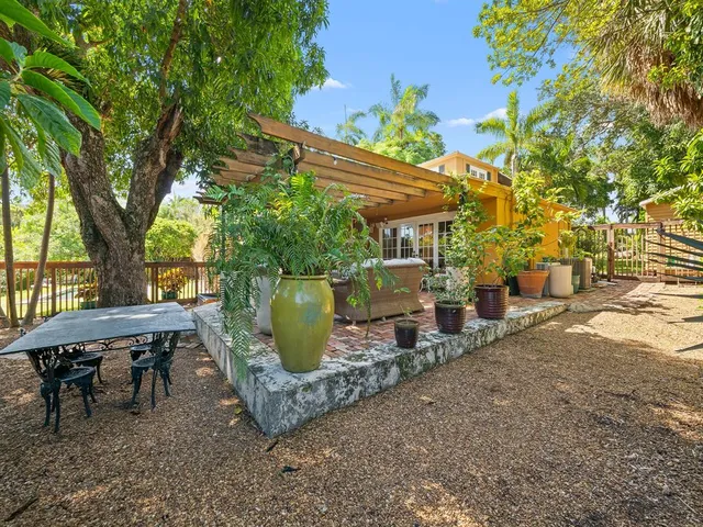 a view of a patio with table and chairs and potted plants