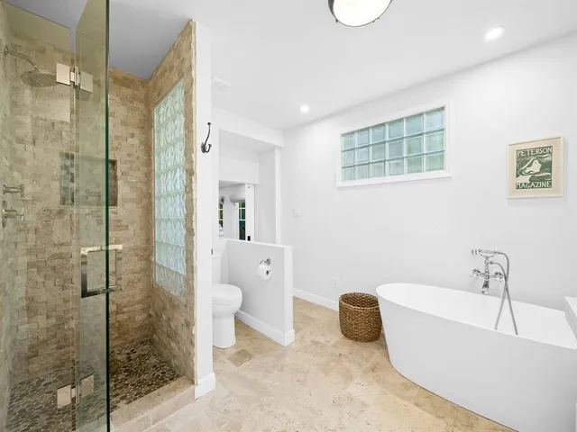 a bathroom with a tub a toilet and a shower