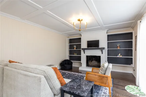 a living room with furniture a fireplace and a flat screen tv