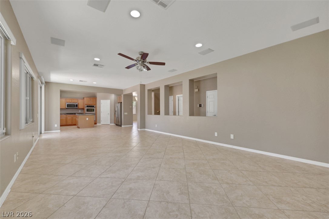 2501 Bechamel Place Henderson, NV 89044 - Photo 13 of 50 An open concept living area features recessed lighting and durable tile flooring, flowing seamlessly into the kitchen.