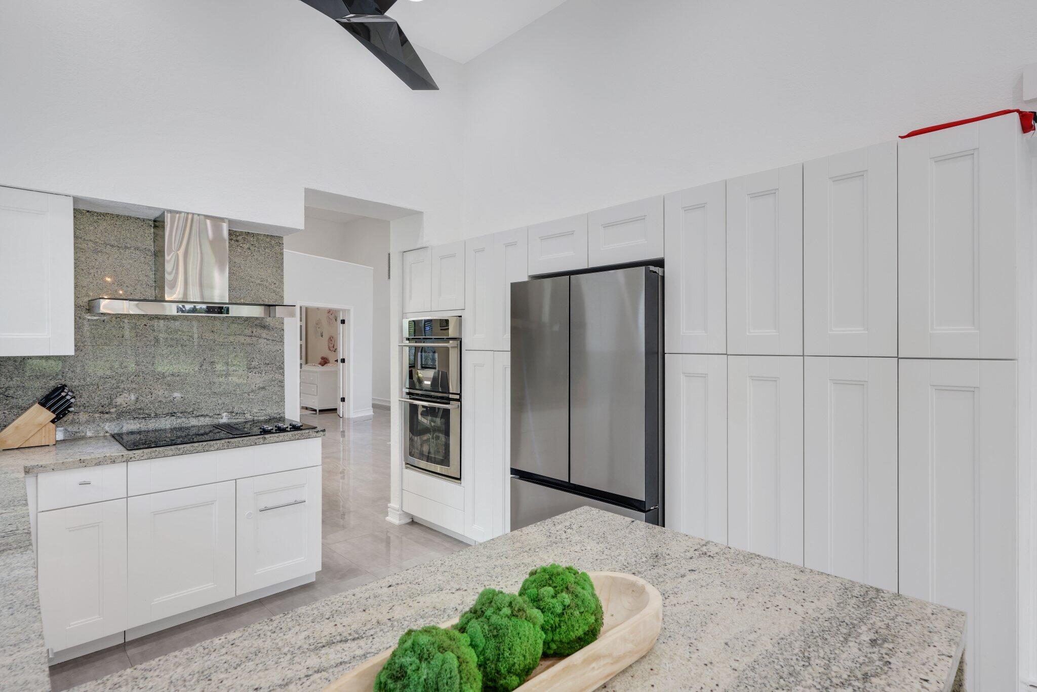 10106 Spyglass Way Boca Raton, FL 33498 - Photo 16 of 44 a kitchen with stainless steel appliances granite countertop a refrigerator and a sink