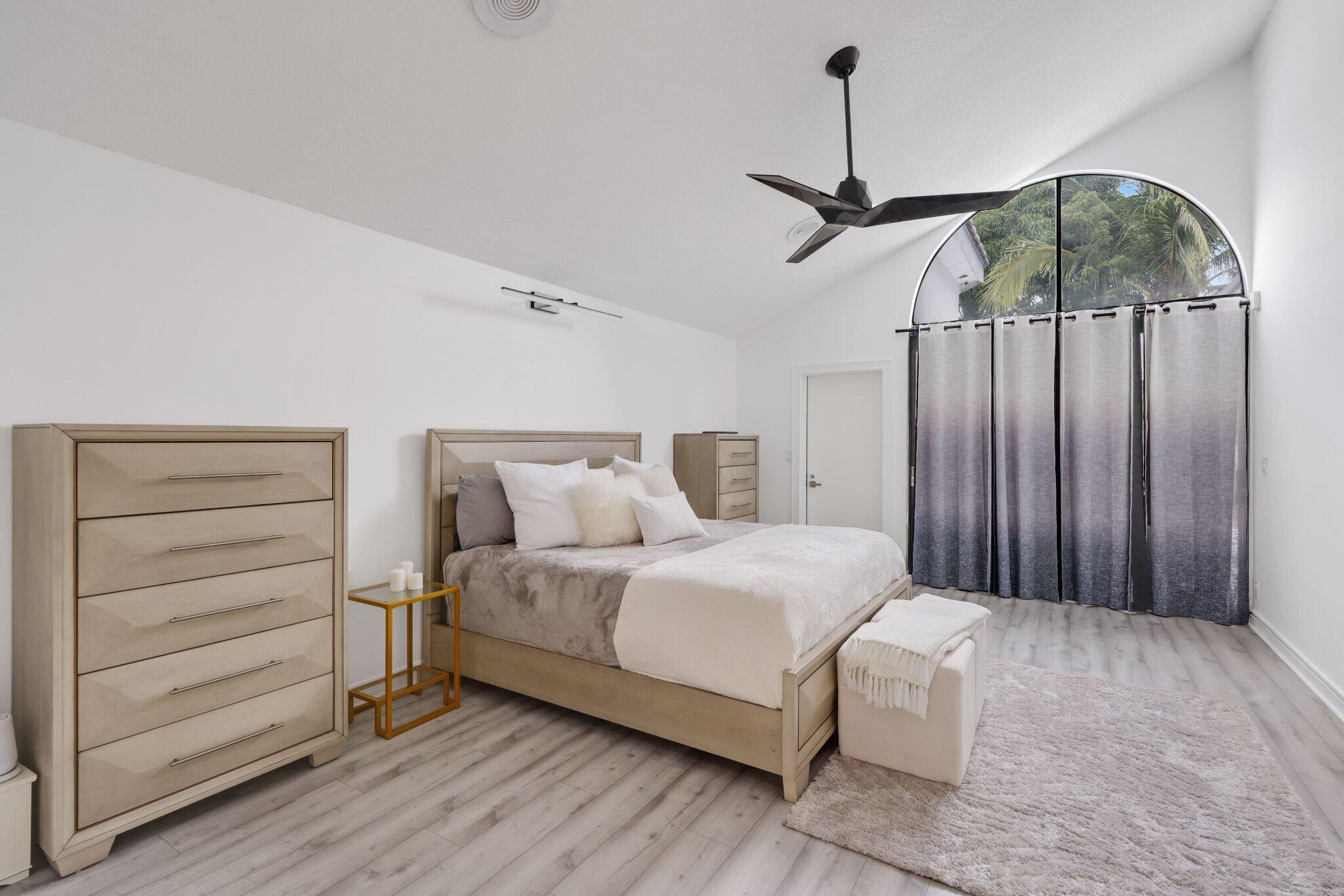 10106 Spyglass Way Boca Raton, FL 33498 - Photo 20 of 44 a bedroom with a bed a dresser and a window