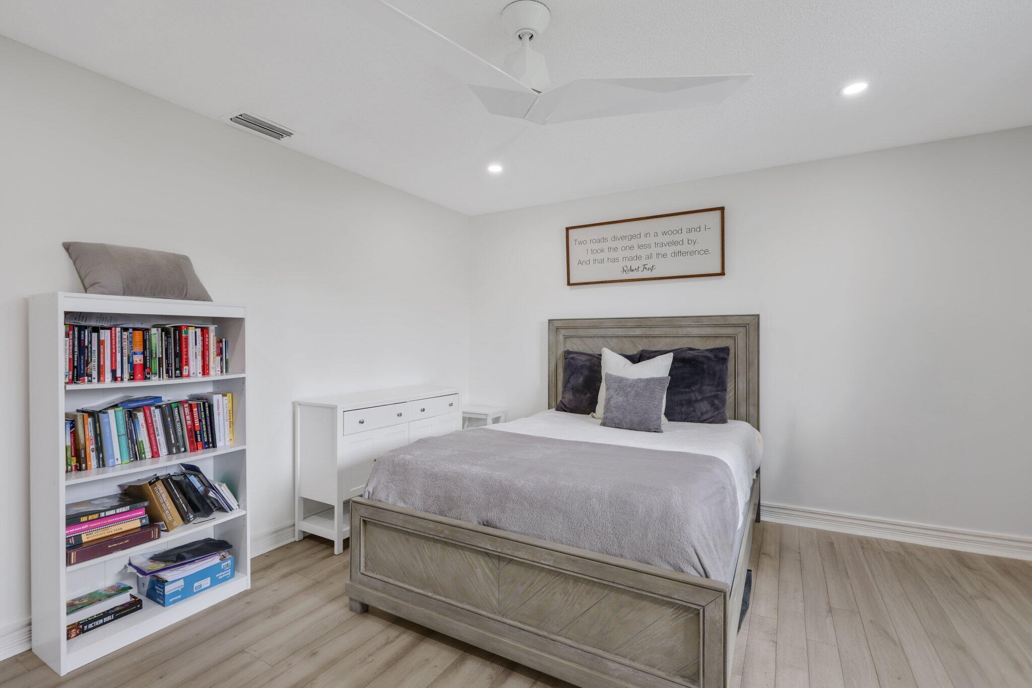 10106 Spyglass Way Boca Raton, FL 33498 - Photo 24 of 44 a bedroom with a bed and a book shelf