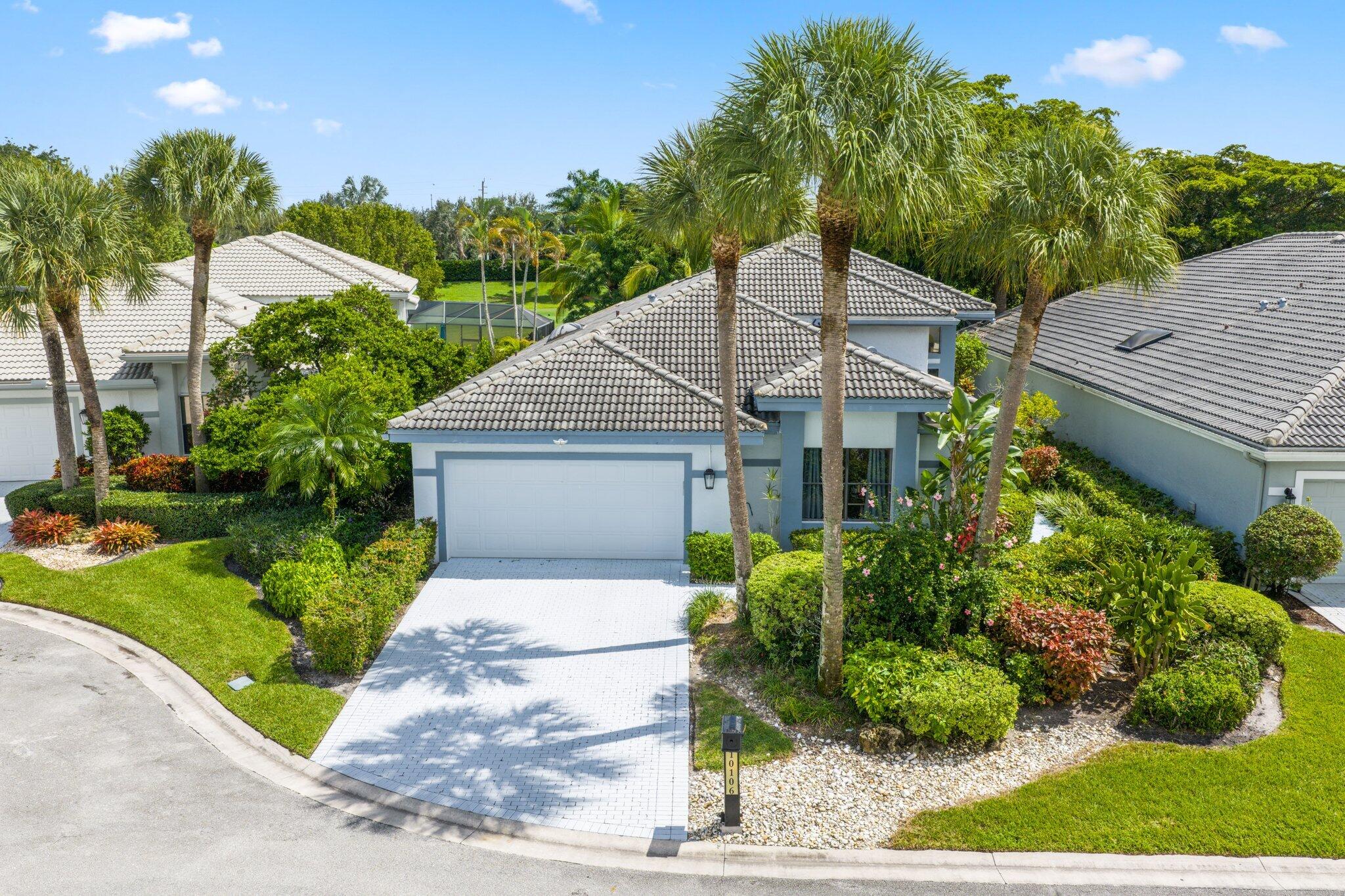 10106 Spyglass Way Boca Raton, FL 33498 - Photo 9 of 44 a front view of a house with a yard and potted plants