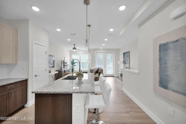 a kitchen with granite countertop kitchen island stainless steel appliances a sink and living room view